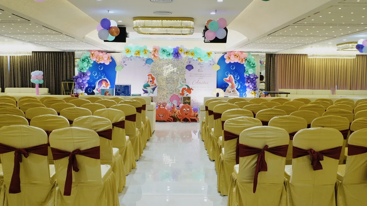 Horizontal image of a calm lake with mountains in the background under a clear blue sky