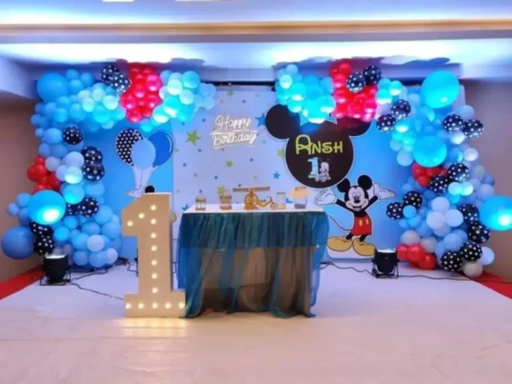 Birthday party with colorful balloons, confetti, and a large cake with candles