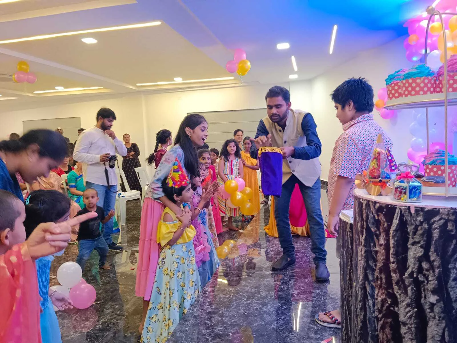 Kids birthday party with colorful balloons, a clown entertainer, and a decorated cake table