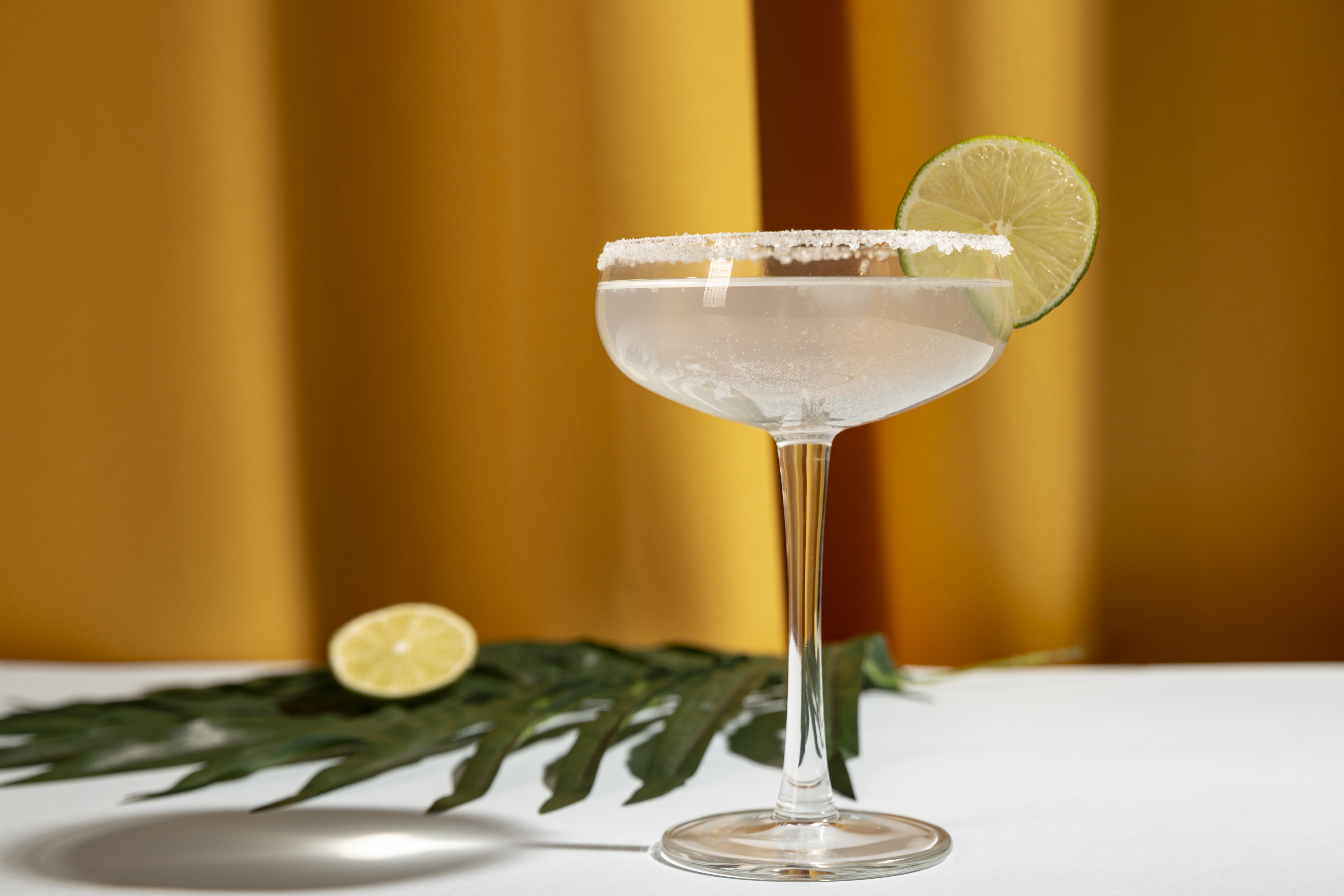 Classic margarita cocktail with salted rim and lime