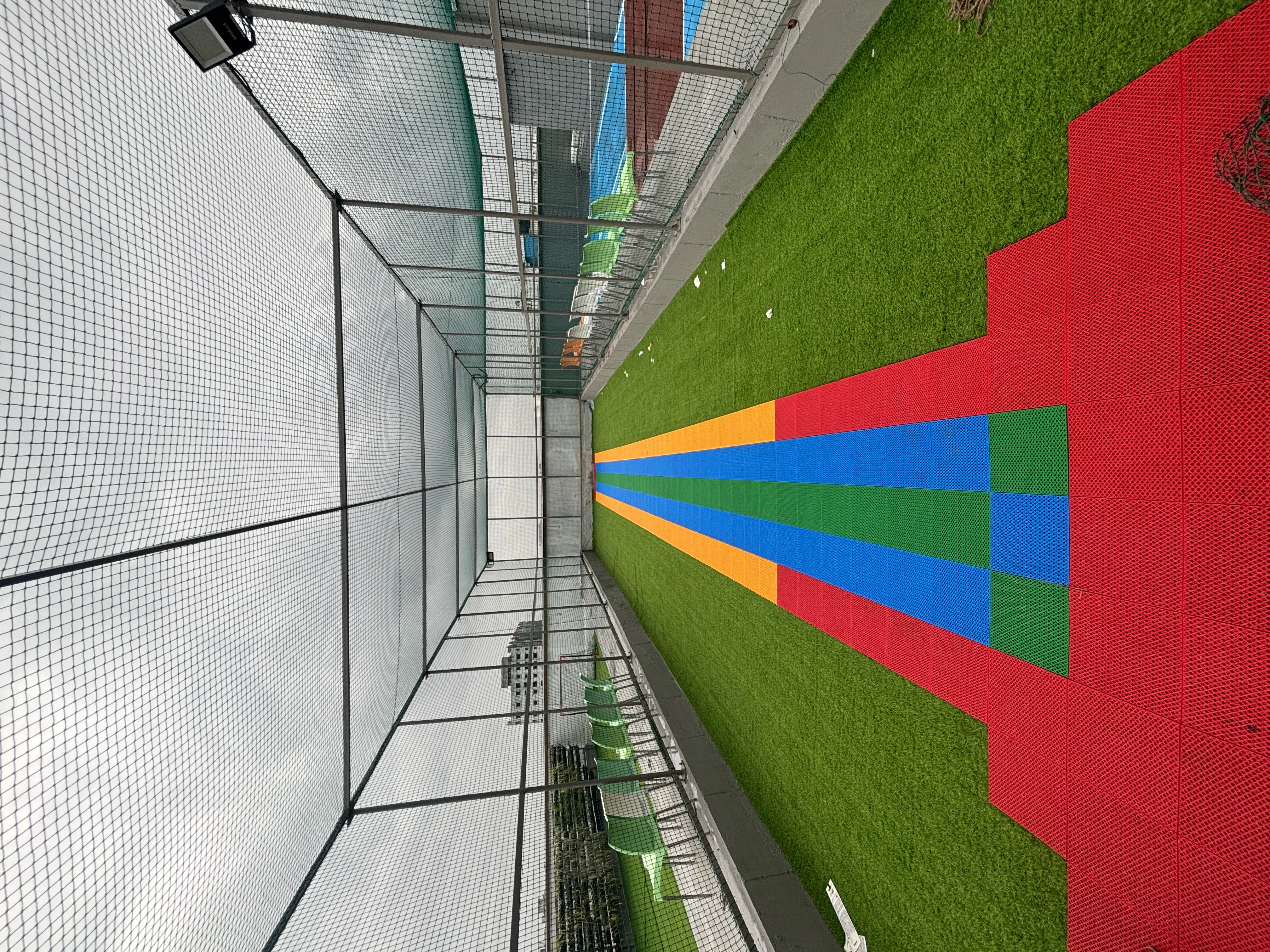 Pickleball paddle hitting a ball mid-air on a blue court with net in background